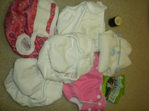 5 assorted covers, detergent samples, contour diaper, snappi, and diaper cream sample